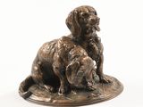 statue représentant deux chiens assis sur une assiette posée sur une surface blanche