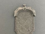 a silver metal mesh purse with a chain around it