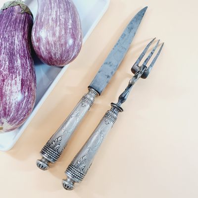 purple eggplant, knife, and fork sitting on a white plate