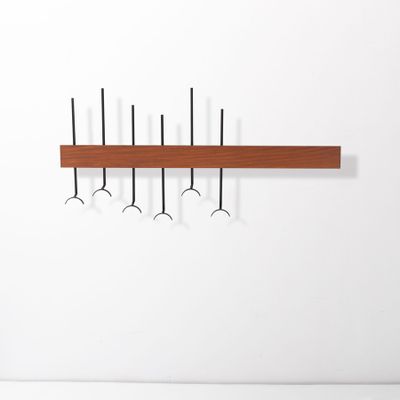 a wooden shelf with hooks and hooks hanging on it