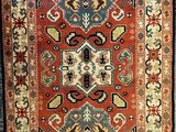 a red and blue rug with an ornate design on it