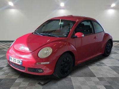 a picture of a red vw beetle parked in a garage