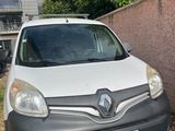 grey and white van parked in front of a building next to a brick wall