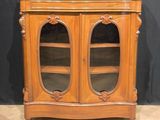 a wooden cabinet with two glass doors on top of it