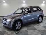 une photo d'un SUV Suzuki argenté garé dans un garage