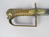 a close up of a sword on a white surface