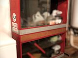a red cabinet with two glass shelves on the wall