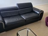 un canapé en cuir noir et un fauteuil en cuir violet dans un salon