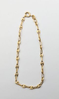 un collier à chaîne en or avec un maillon allongé sur fond blanc