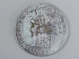 a silver coin with a picture of a man riding a horse