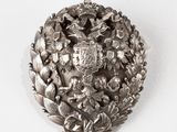 une broche en argent ornée de fleurs et de feuilles