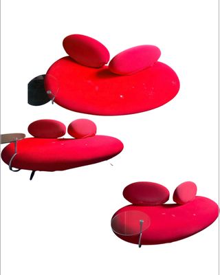 une chaise rouge sur laquelle est posé un coussin en forme de cœur