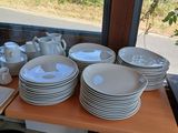 many plates and cups on a table in a restaurant