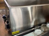 a stainless steel sink in a kitchen with a lot of bottles in it