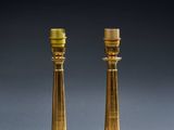 a pair of brass candles on a table next to a mouse