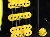 yellow and black electric guitar sitting on top of a black table