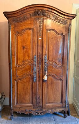 a large wooden armoire in the corner of a room