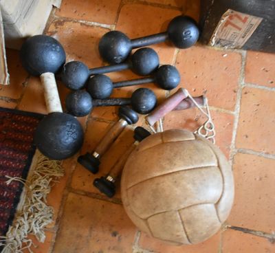 un ballon, une batte de baseball et d'autres équipements sportifs sur le sol