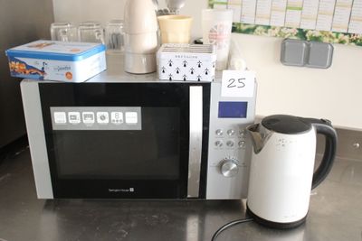 a microwave that is sitting on a counter with a tea kettle