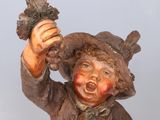 a statue of a boy with a hat holding a leaf