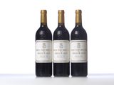 three bottles of wine are lined up on a white surface