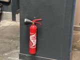 a fire extinguisor attached to the door of a building