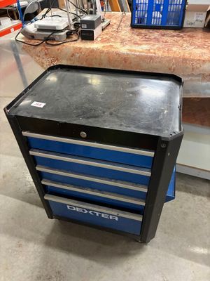 une armoire à outils bleue posée à même le sol dans un garage