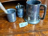 three cups and a spoon sitting on a wooden table