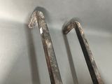 pair of antique iron and brass handles on a wooden chair