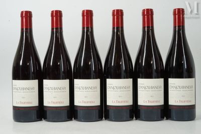 six bouteilles de vin rouge sont alignées sur une table