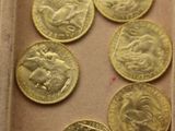 beaucoup de pièces d'or dans une boîte posée sur la table