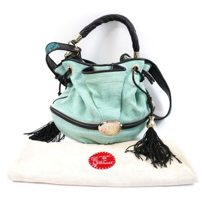 purse with tassels on a pillow on a white surface