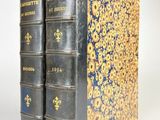 un vieux livre aux couvertures dorées et bleues, posés les uns sur les autres