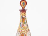 a glass bottle with a red and yellow design on it