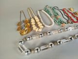 a lot of different necklaces and bracelets on the table