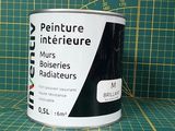 un pot de peinture posé sur un tapis de découpe