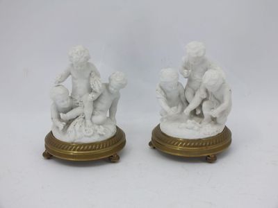 pair of white marble figurines of children playing with a ball