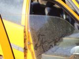 a close up of a yellow car with a dirty window