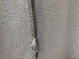 the back of a gray sweater with a zipper on it