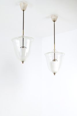 deux suspensions en verre suspendues au plafond dans une pièce blanche
