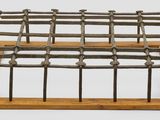 une cage métallique surmontée de poteaux en bois