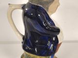 a blue and white pitcher with a black hat on it