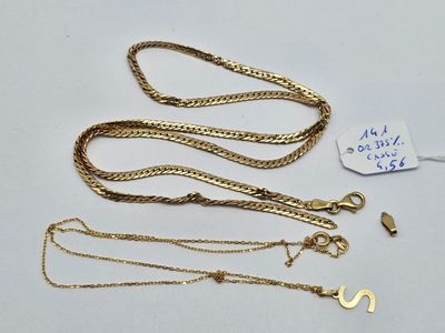 trois colliers en or et une chaîne en or avec une étiquette de prix