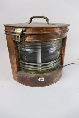 an old copper light that is sitting on a table