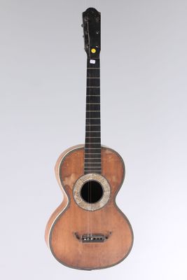 a small wooden guitar with a hole in the neck