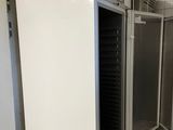 un réfrigérateur blanc au milieu d'un sol carrelé