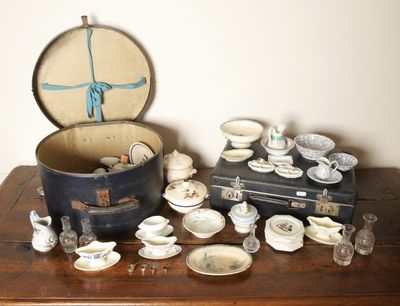 une table sur laquelle se trouvent une valise et tout un tas de vaisselle