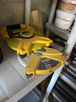 yellow and black tools are sitting on a shelf in a garage