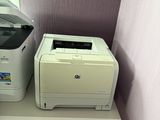 two printers sitting on a shelf next to a window