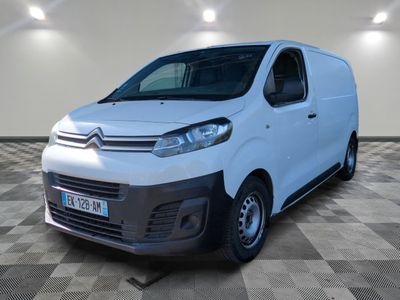la camionnette blanche est garée dans une grande pièce au sol en damier